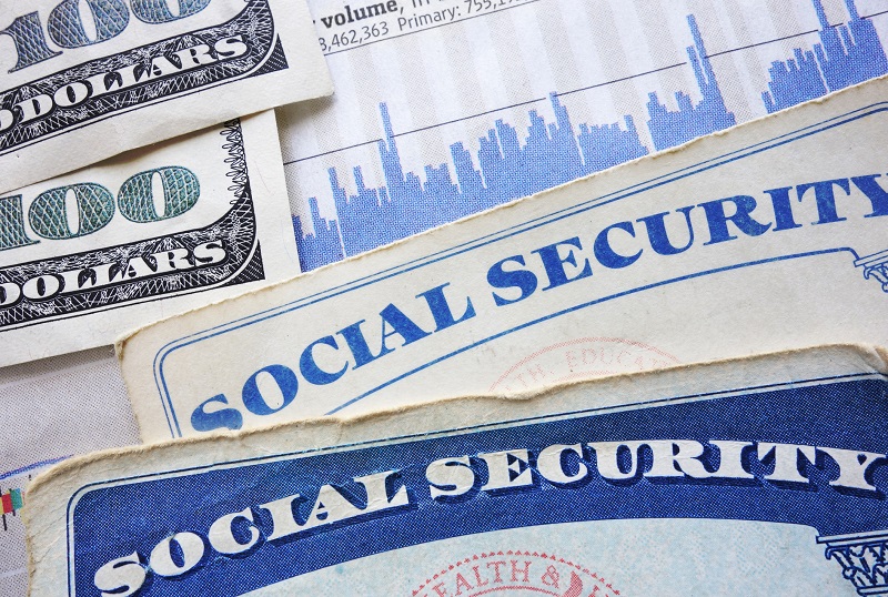 Social Security cards, cash and stock market chart