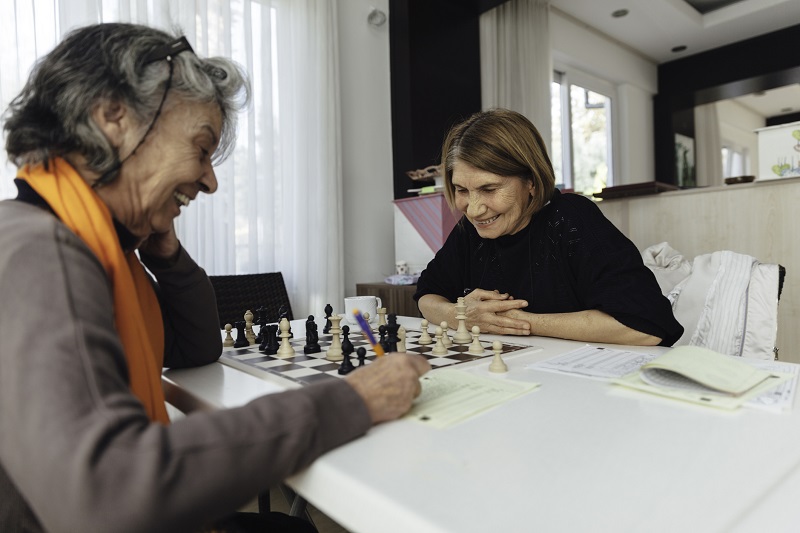 Cheerful  senior woman playing chess
